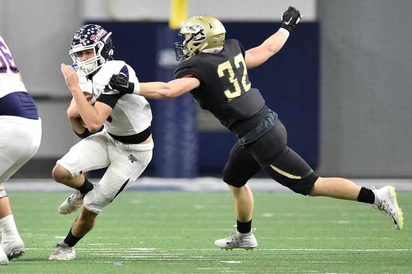 Denton Ryan-Birdville game.
Ryan quarterback Seth Henigan (6) carries the ball, while being...