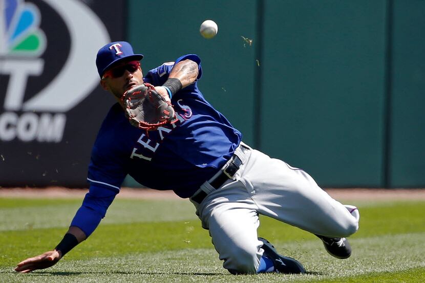 CHICAGO, ILLINOIS - APRIL 23: Ian Desmond #20 of the Texas Rangers makes a catch for an out...