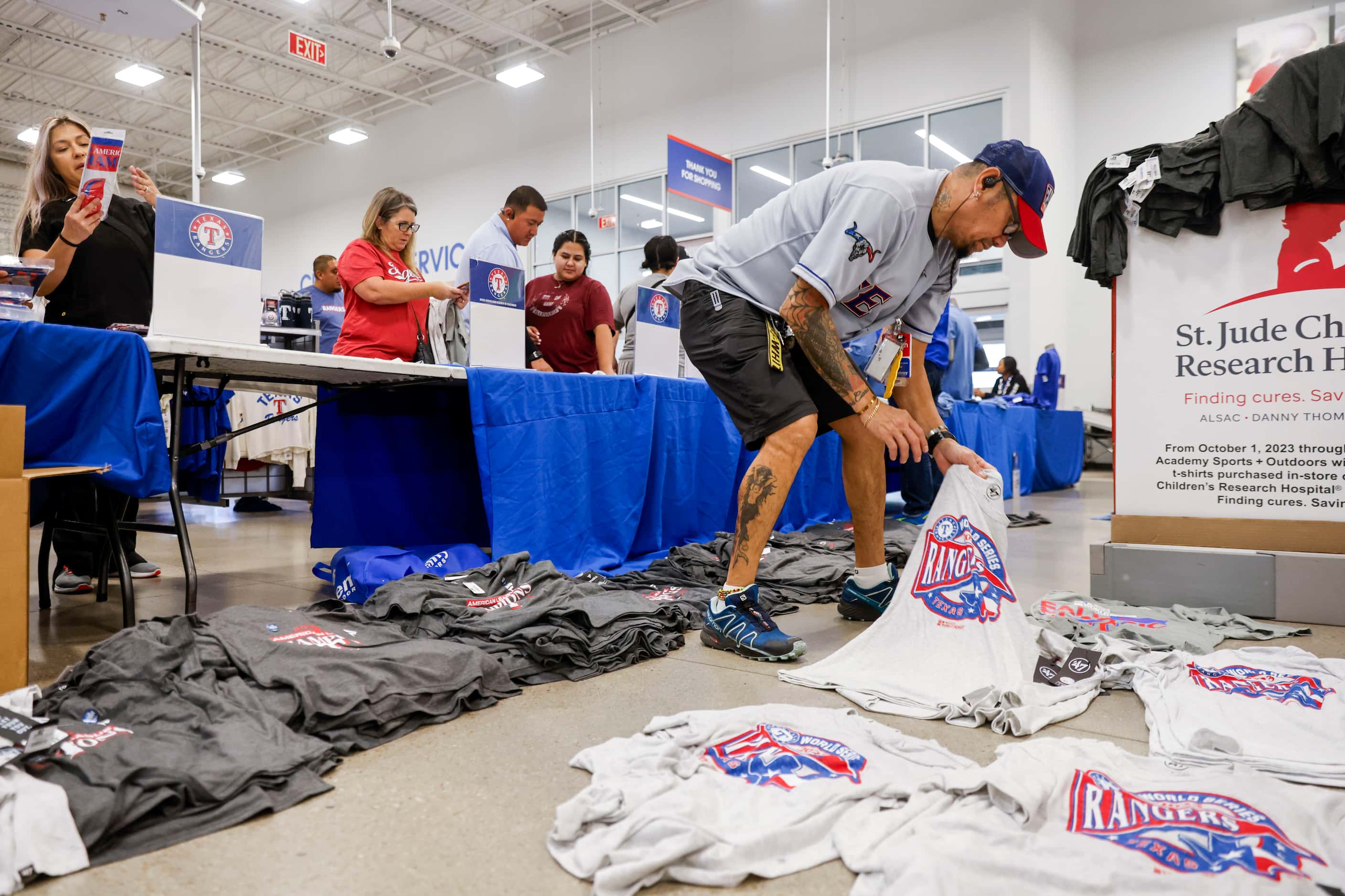 Academy Sports + Outdoors employee Allan Molina (right) provides the customers with Texas...
