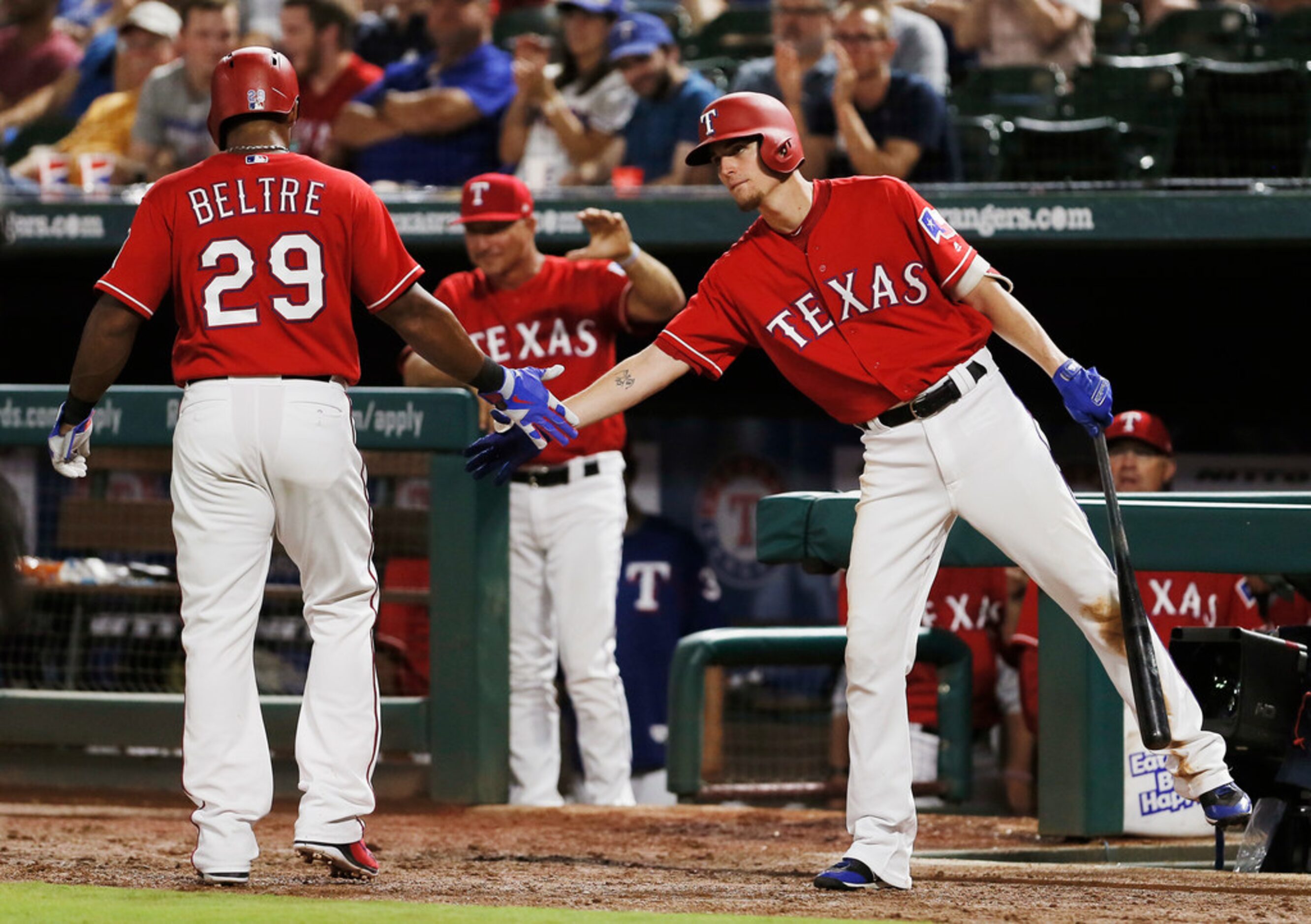 Texas Rangers' Adrian Beltre (29) is congratulated by Carlos Tocci, right, after scoring on...