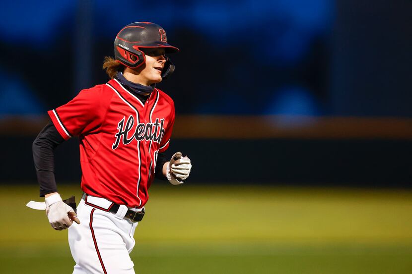 Rockwall-Heath’s Jonny Lowe rounds third after hitting a grand slam during a district 10-6A...