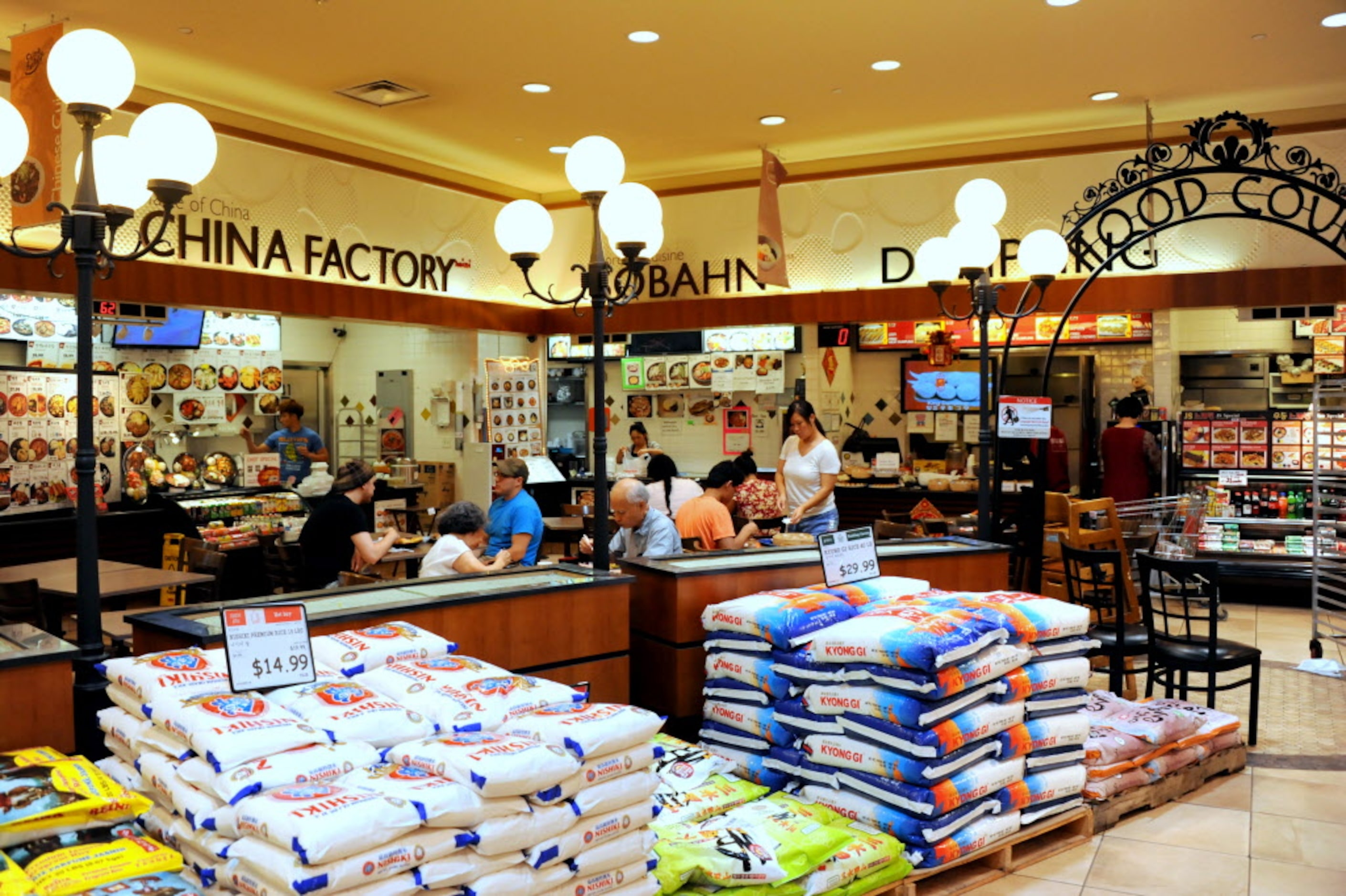 Shoppers grab a bite to eat in the food court before grocery shopping at H Mart in...