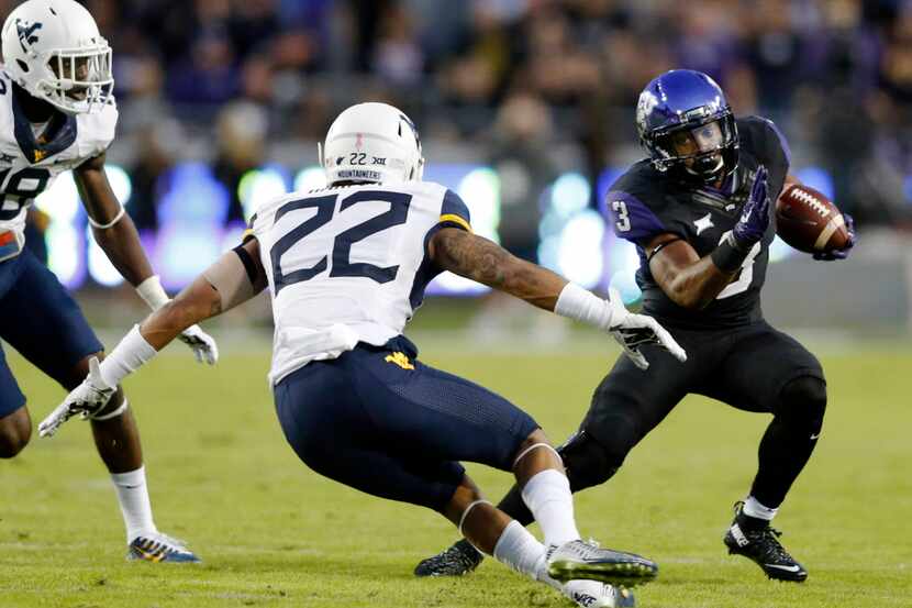 TCU Horned Frogs running back Shaun Nixon (3) shakes off West Virginia Mountaineers safety...