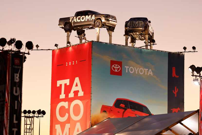 Toyota pickup trucks sit atop a display outside the automobile building during the State...