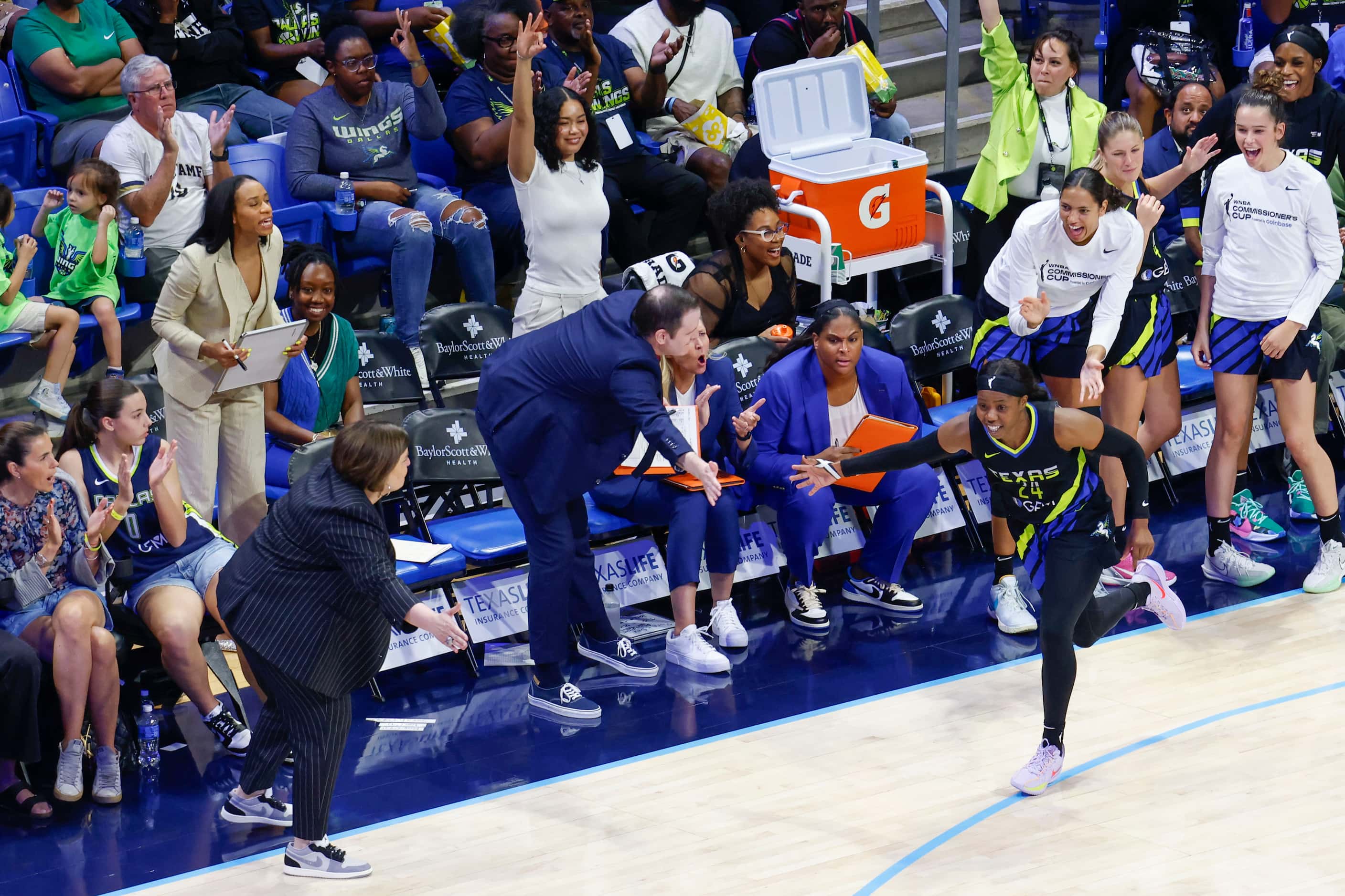 Dallas Wings guard Arike Ogunbowale (right) hi fives her teammates on the bench after...