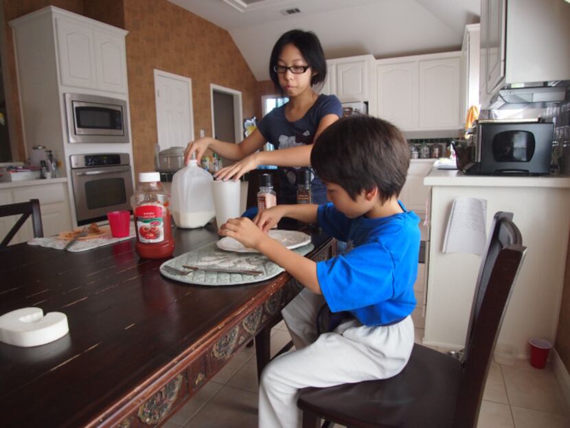 Paris Roberson, 14, left, and her brother Preston, 9, enjoy breakfast May 18. They are two...