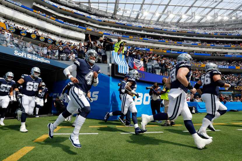 Dallas Cowboys quarterback Dak Prescott (4) races onto the field with teammates to face the...