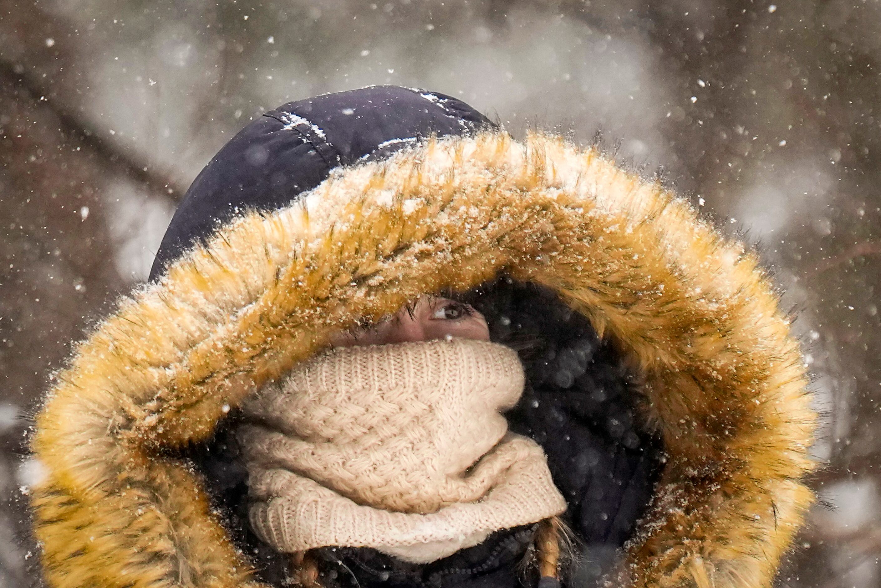 Roxie Hunter bundles up against the cold as snow falls in Prairie Creek Park as a winter...