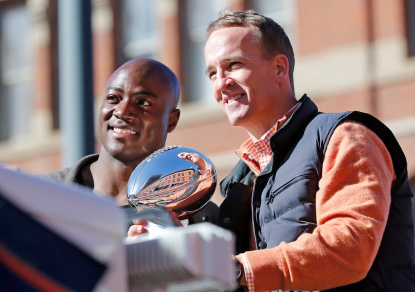 Denver Broncos quarterback Peyton Manning and defensive end DeMarcus Ware hold the Lombardi...