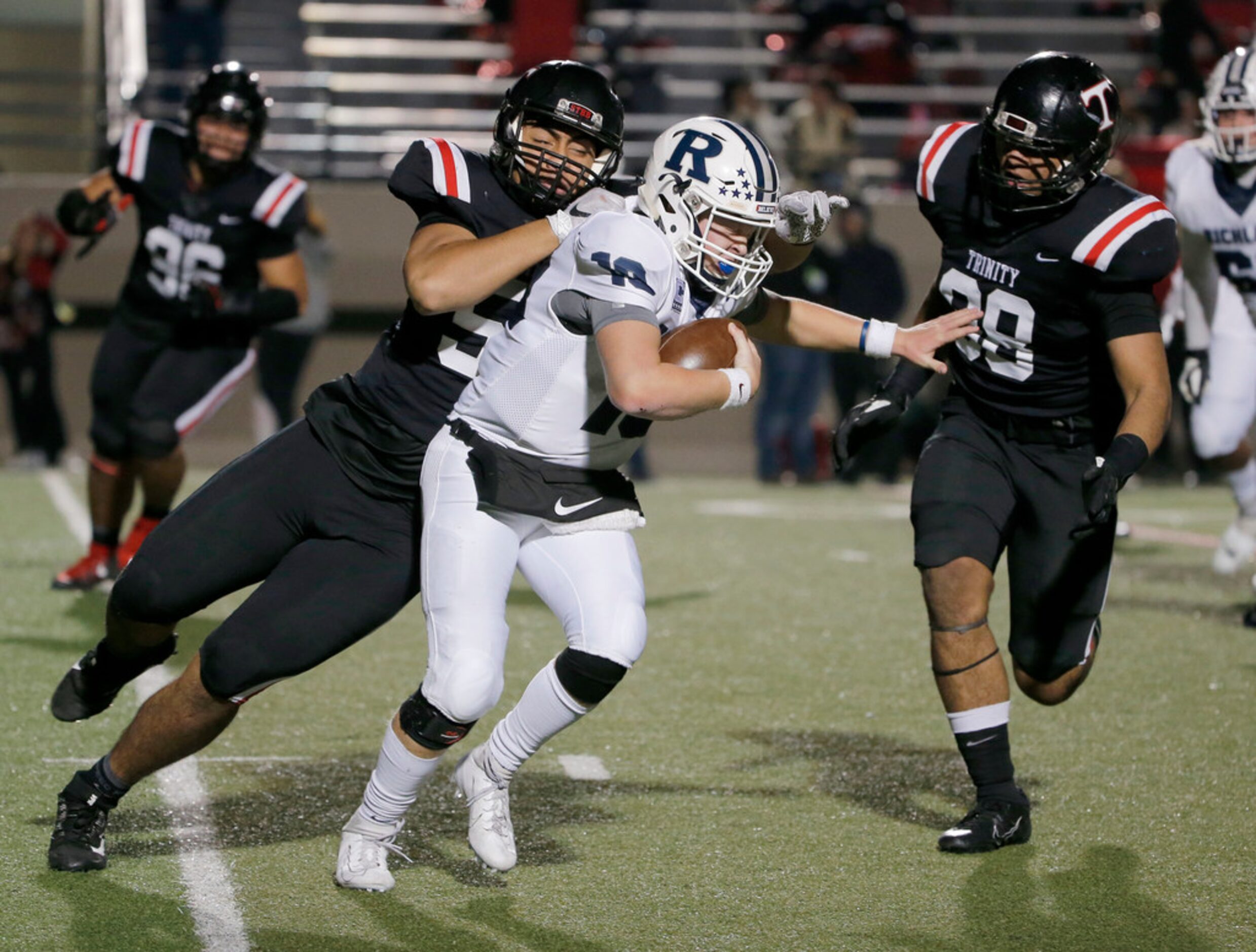 Trinity's Tonga Lolohea (54) and Tevita Leka (98) sack Richland quarterback Cole Benson (10)...