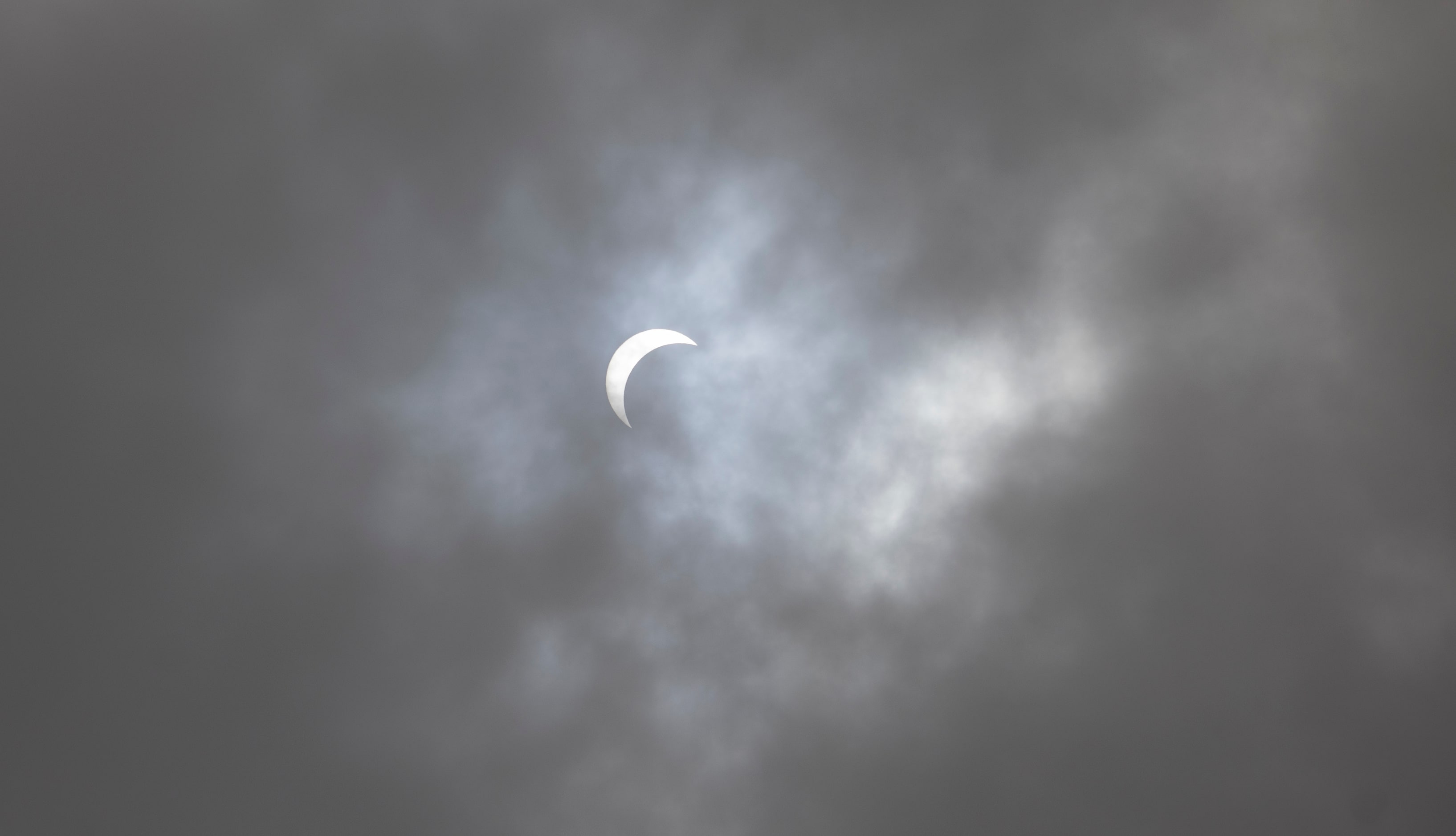 A break in the clouds shows the eclipse nearing totality during the Great North American...