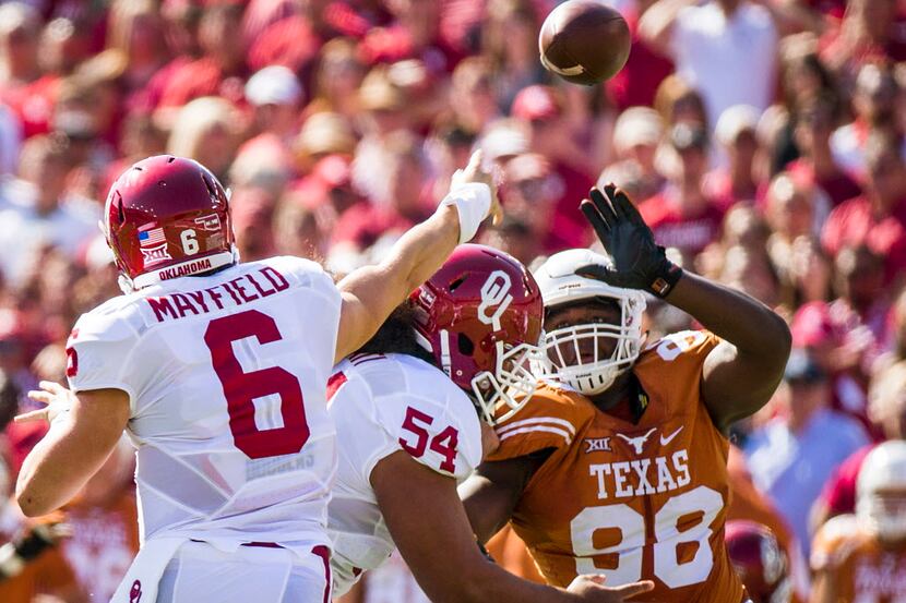 Oklahoma quarterback Baker Mayfield (6) passes under pressure from Texas defensive tackle...