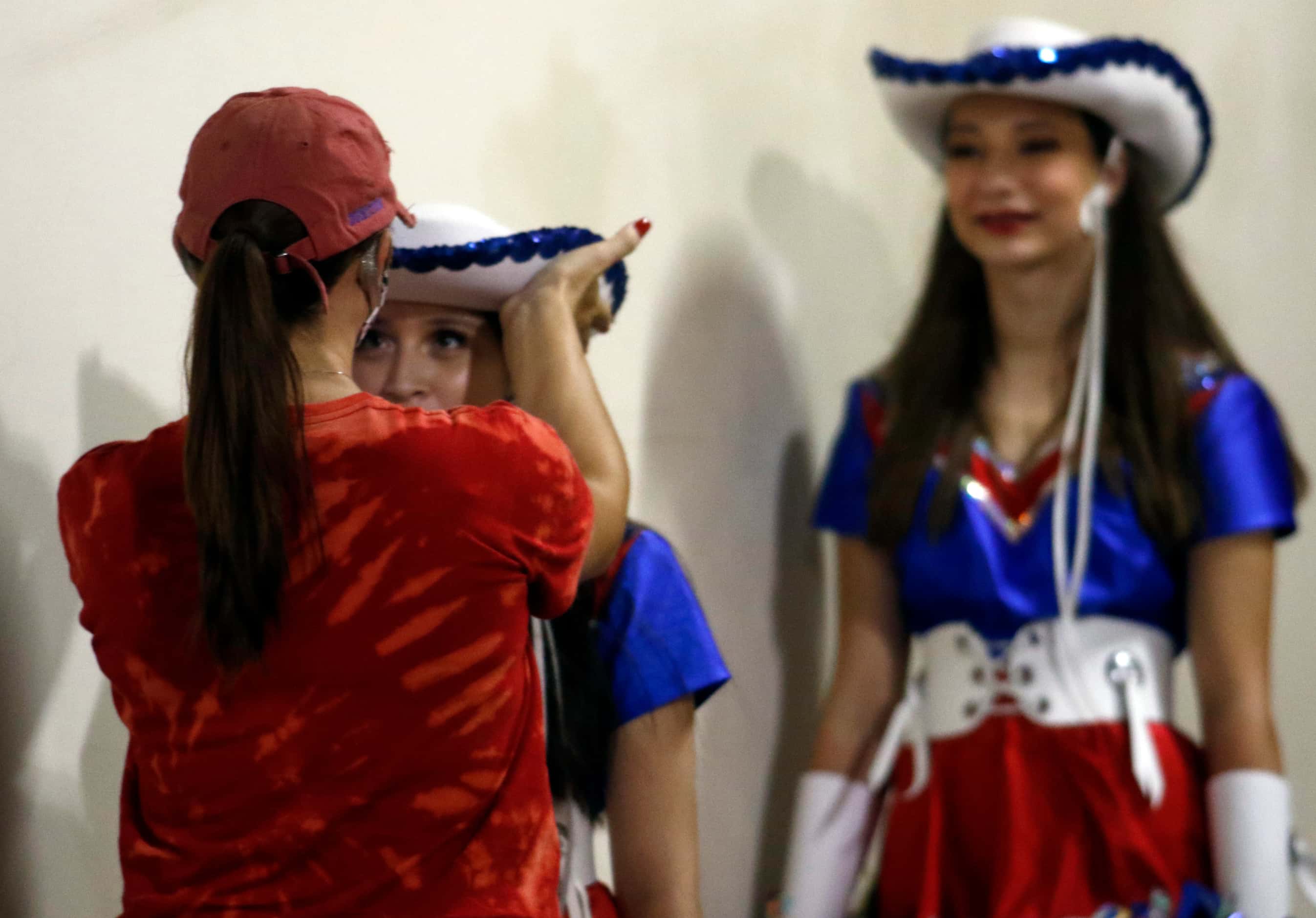 A Midlothian Heritage drill team member receives a last minute adjustment before heading...