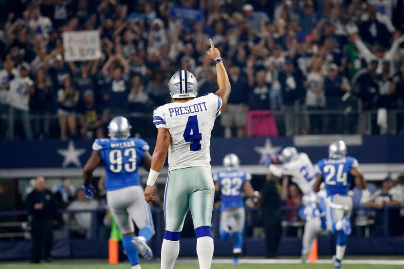 Dallas Cowboys quarterback Dak Prescott (4) raises his hand as running back Ezekiel Elliott...