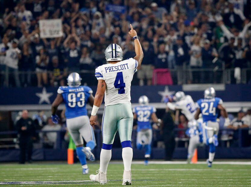 Dallas Cowboys quarterback Dak Prescott (4) raises his hand as running back Ezekiel Elliott...