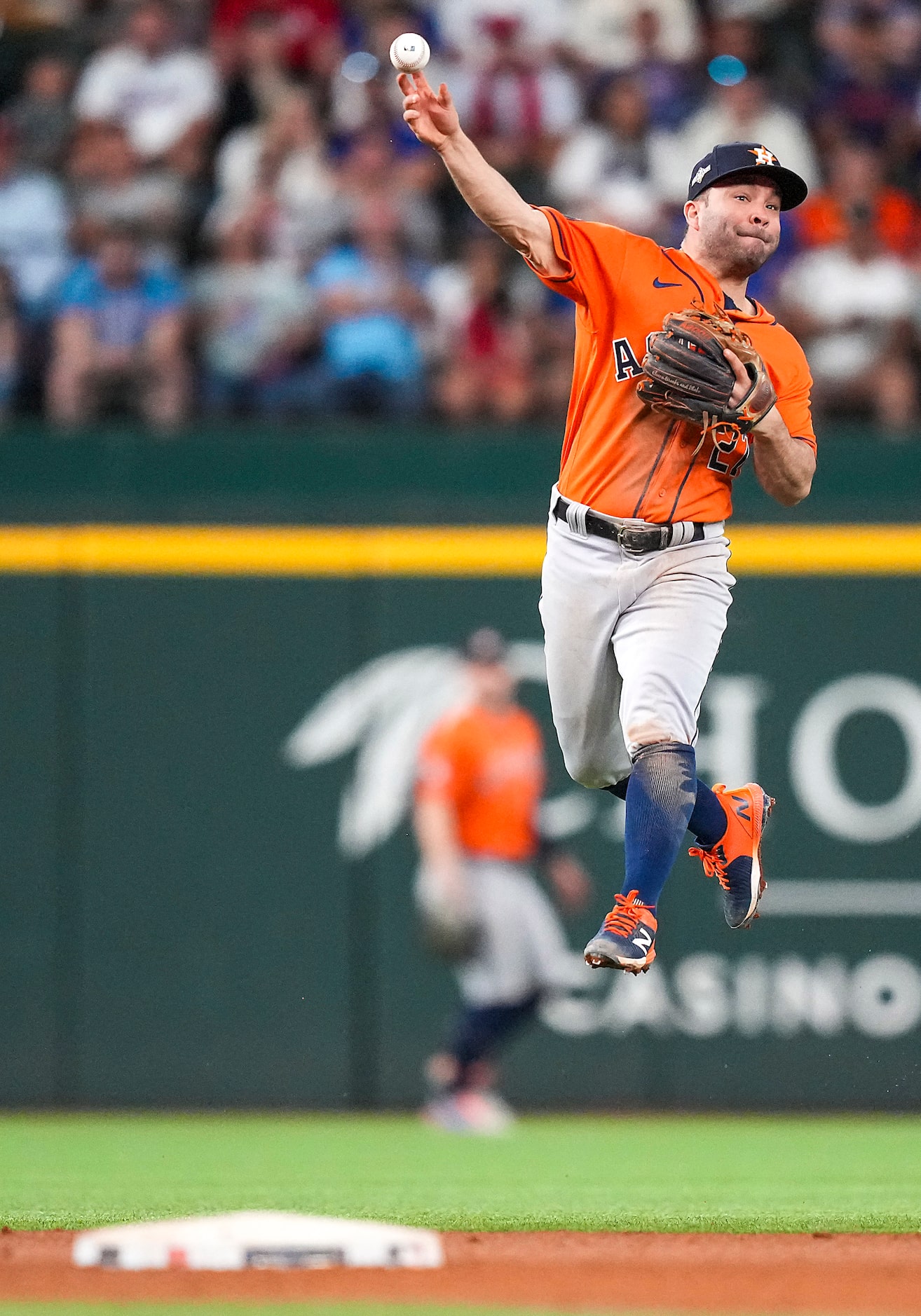 Houston Astros second baseman Jose Altuve makes a leaping throw to get Texas Rangers third...