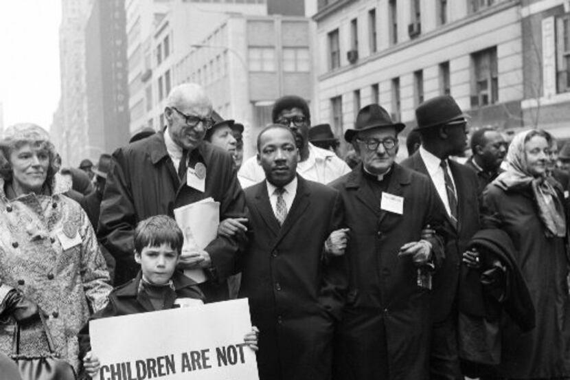Civil rights leader Rev. Martin Luther King, Jr., (center) is accompanied by famed...