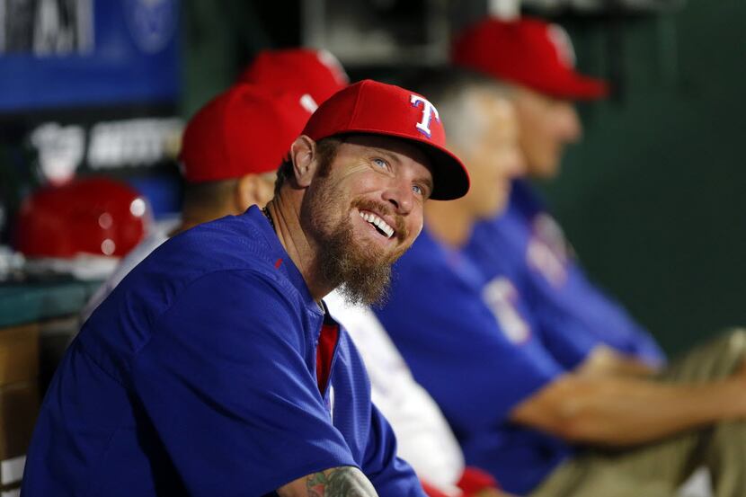 Texas Rangers Josh Hamilton smiles from the bench while talking to coaches  in the dugout...