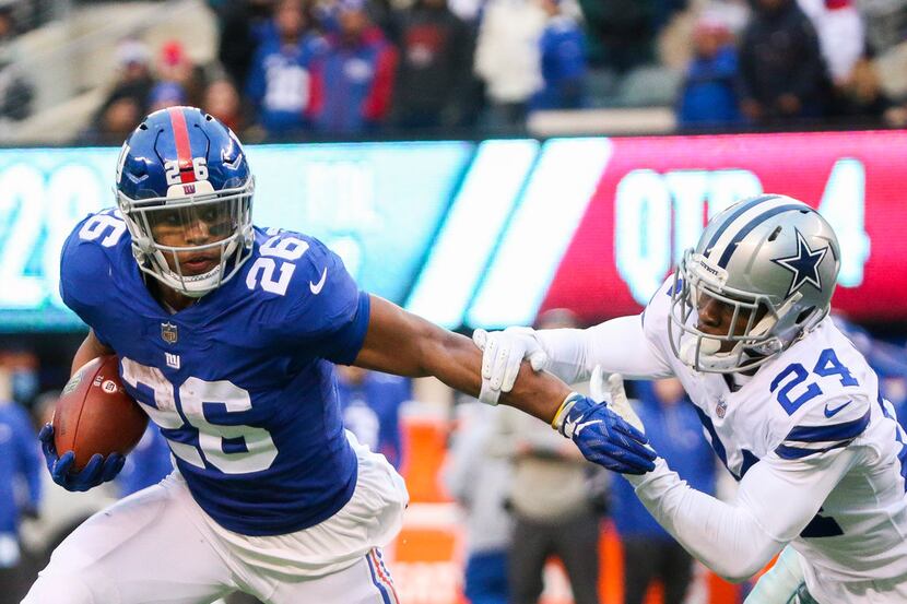 New York Giants running back Saquon Barkley (26) carrie the ball past Dallas Cowboys...