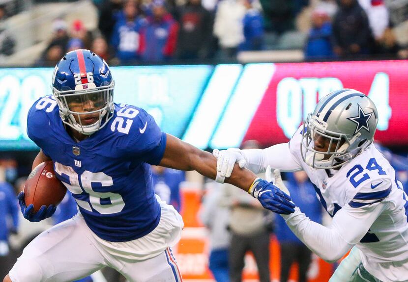 New York Giants running back Saquon Barkley (26) carrie the ball past Dallas Cowboys...