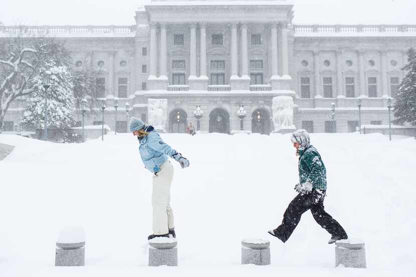  Stephanie Williams and her sister Joely Wilkinson play in the snow in front of the state...