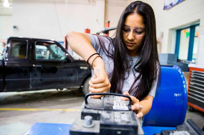  Brianna Aguilar, 18, cleans the contacts on a car battery during an automotive technology...