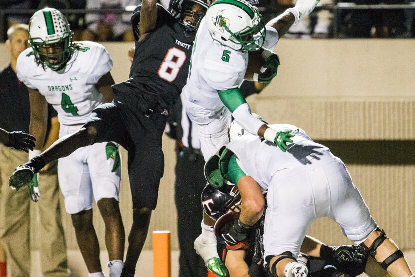 Southlake Carroll running back Shemar Coleman (5) tries to jump over a teammate in to the...