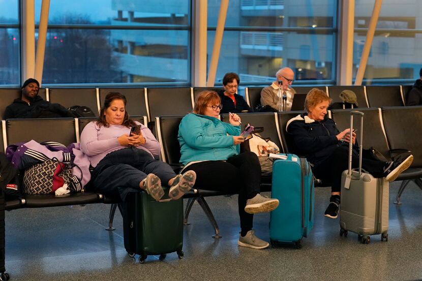 Passengers wait to depart Chicago's Midway Airport as flight delays stemming from a computer...