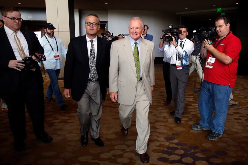 New Baylor head football coach Jim Grobe (center, right) is escorted out of the Big 12...