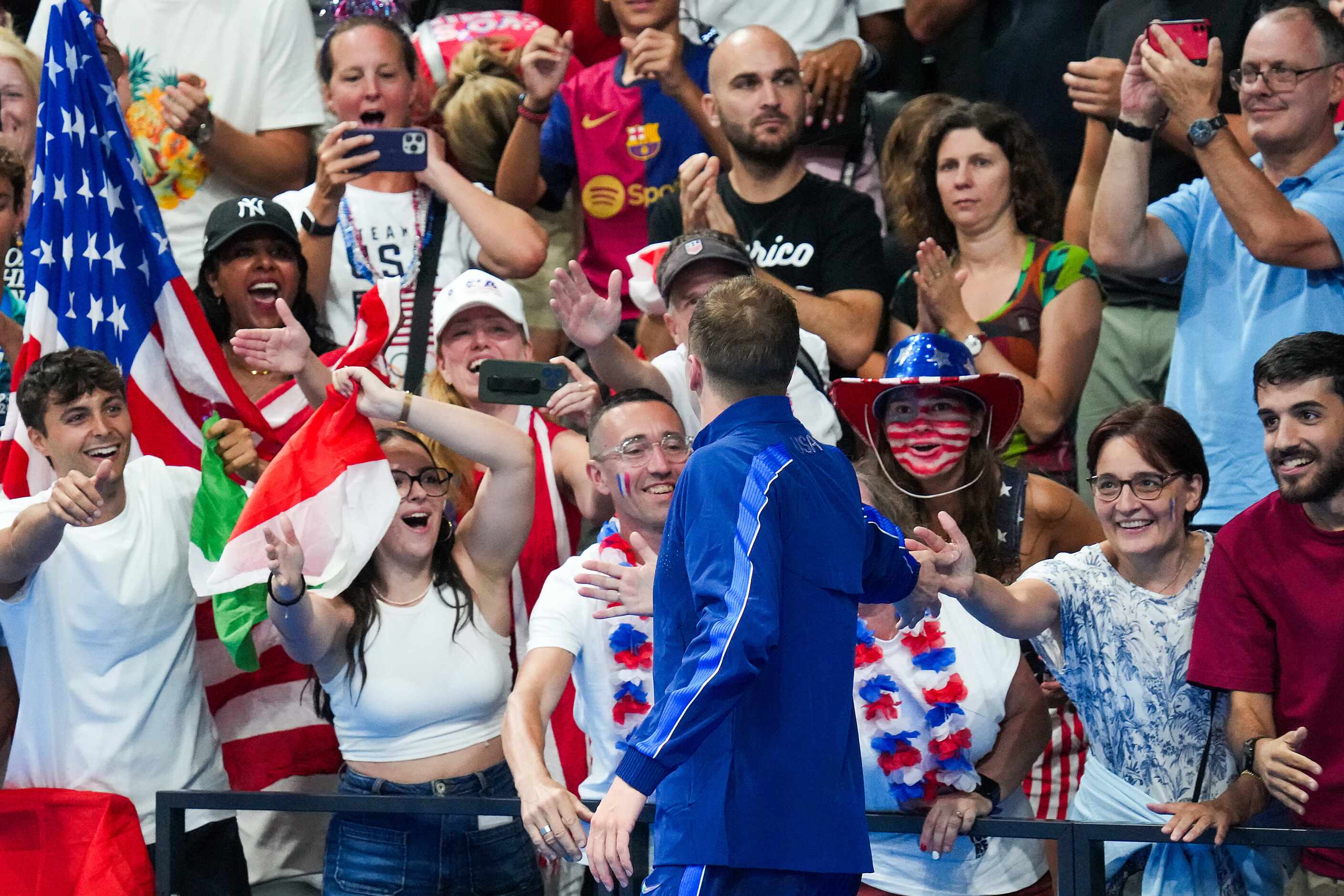 Silver medalist Nic Fink of the United States celebrates with fans after the men's 100-meter...