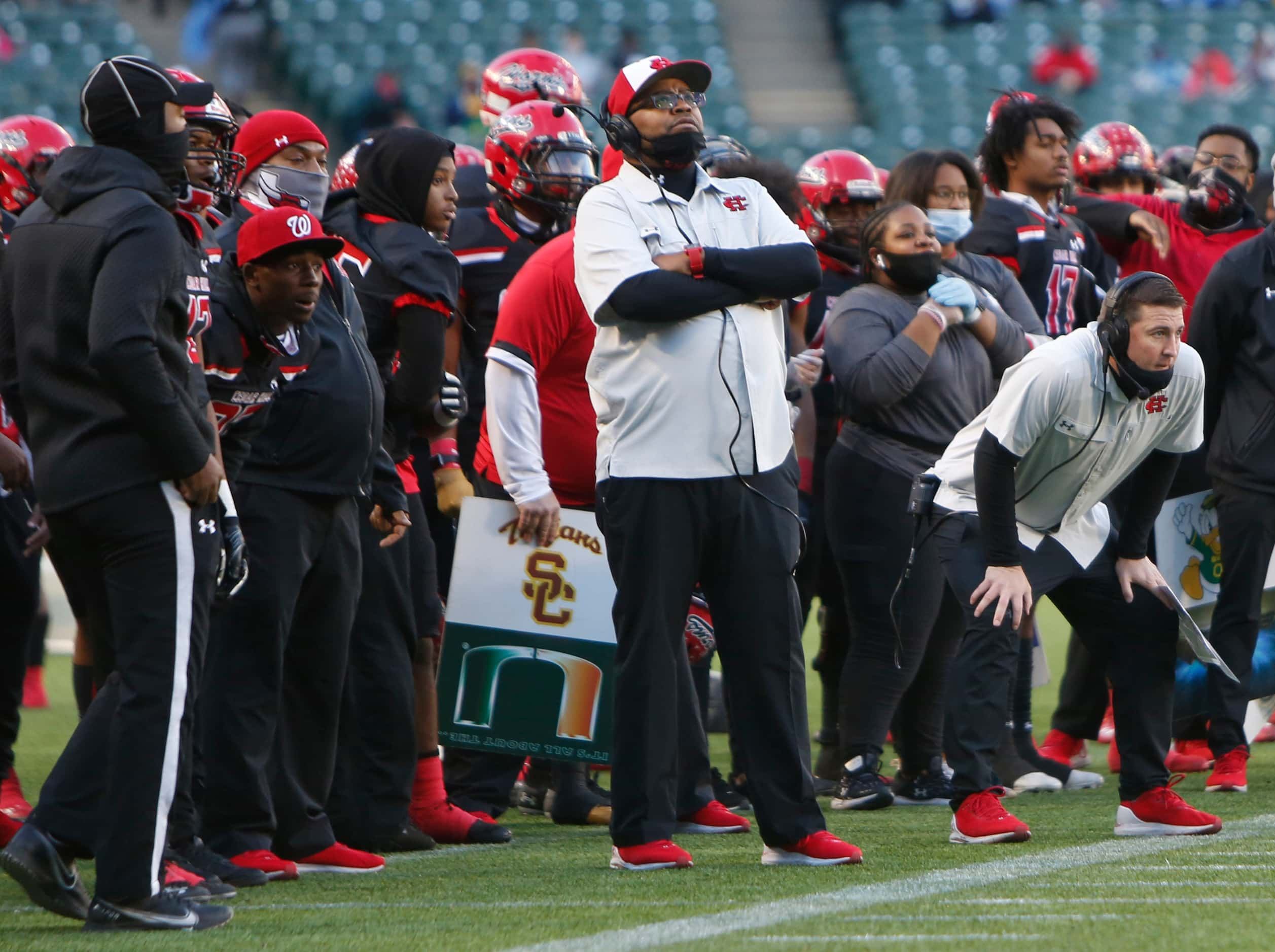 Cedar Hill head coach Carlos Lynn peers upward as he watches from the team sideline at a...