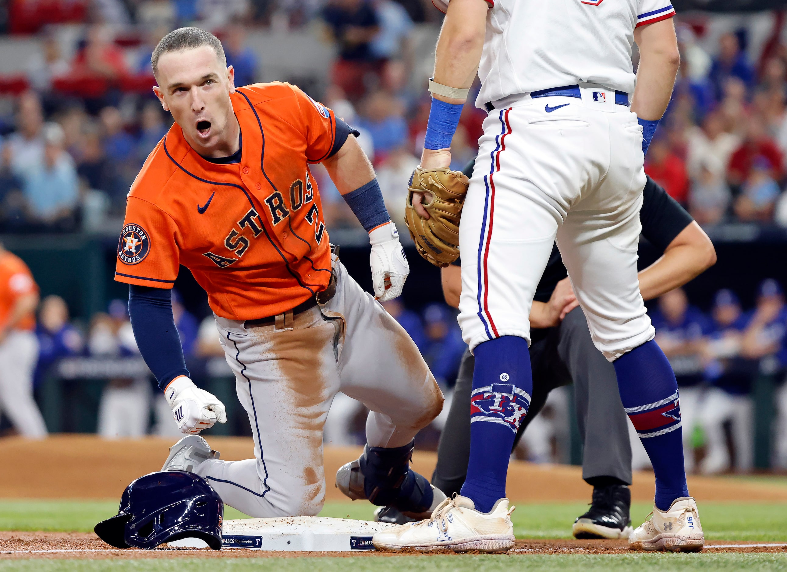 Houston Astros Alex Bregman (2) reacts after sliding safely into third base on a 2-run...