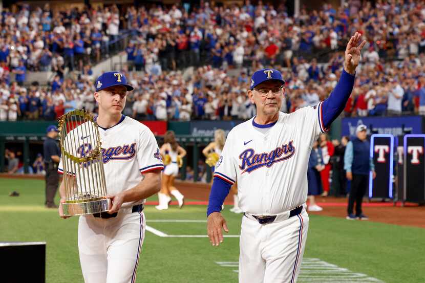 Texas Rangers relief pitcher Josh Sborz carries the World Series championship trophy as...