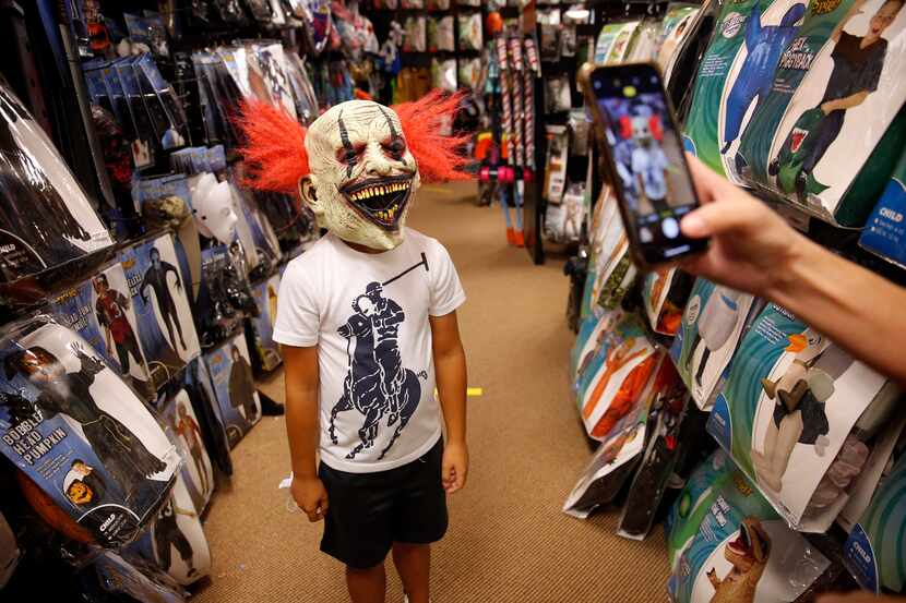 Carey Marin of Richardson takes a photo of her son, Joshua, wearing a clown mask at Spirit...