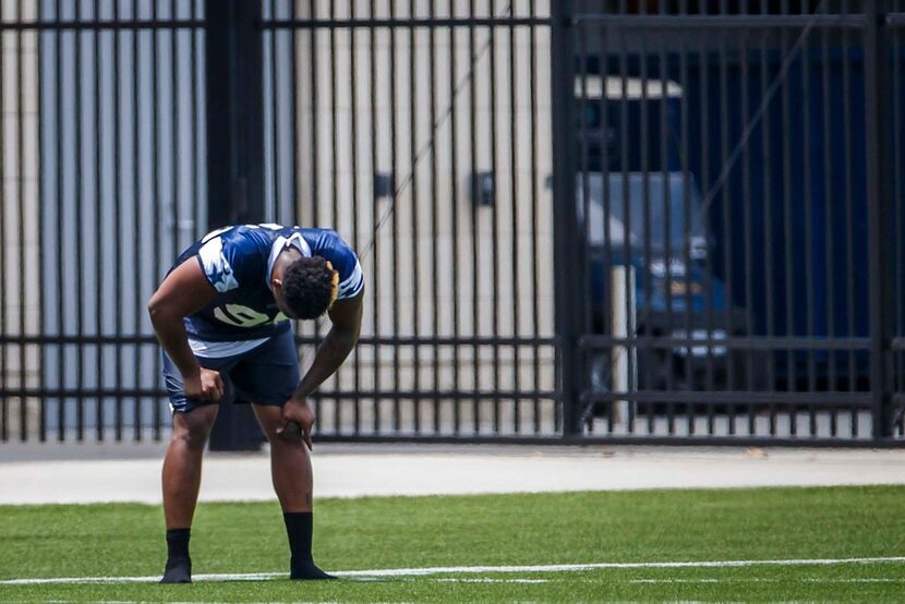 Dallas Cowboys defensive tackle David Irving catches his breath while running on a side...