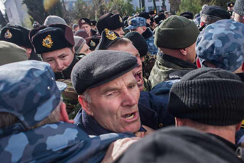Members of a pro-Russian militia scuffle with Ukranian troops Wednesday as they try to enter...
