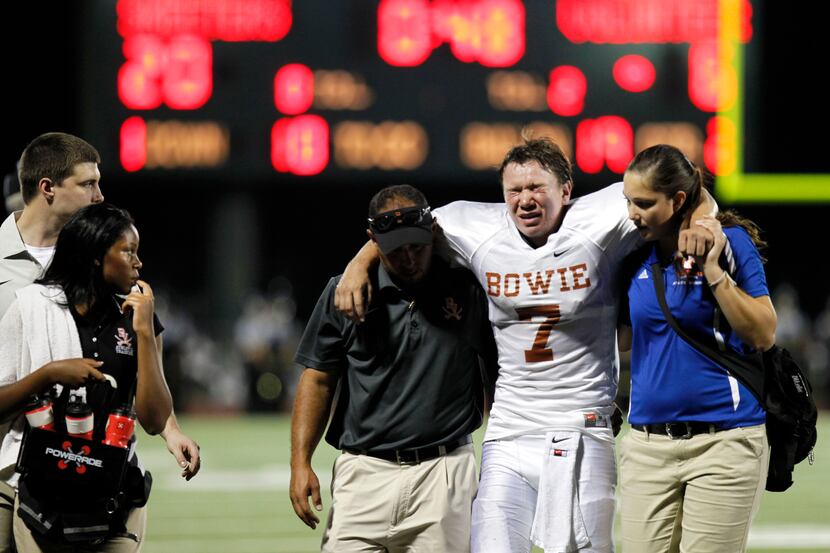 Arlington Bowie Volunteers Keaton Perry (7) is helped off the field after an injury in the...