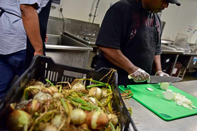 Chef Derrick Thomas slices freshly picked onions from Big Tex Urban Farms at Cornerstone...