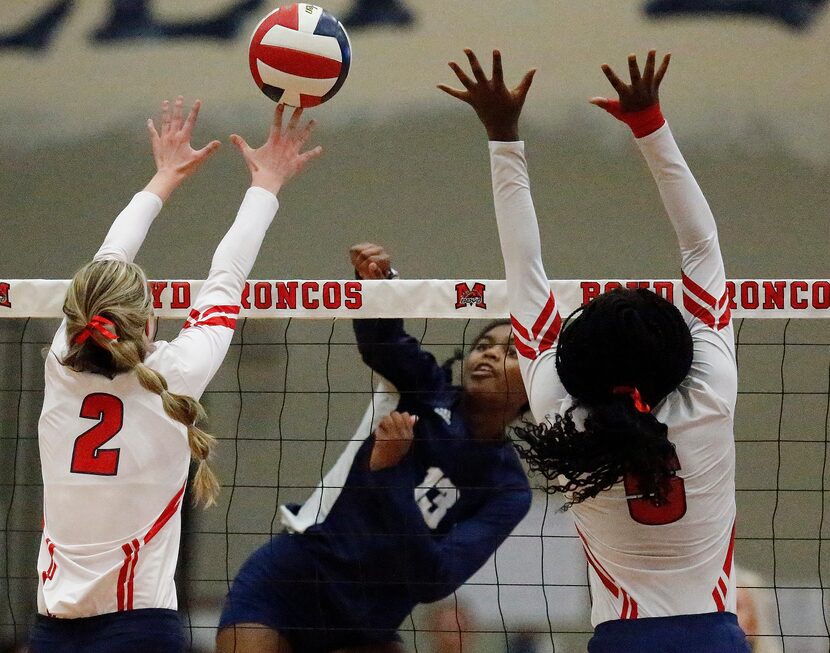 Flower Mound High School outside hitter Brianna Watson (13) gets a hit between McKinney Boyd...