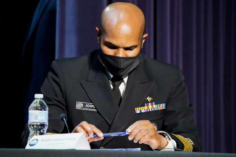 Surgeon General Jerome Adams takes notes during a roundtable conversation about race...