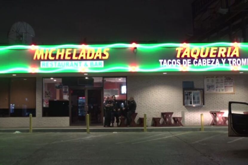 Police officers stand outside Micheladas Restaurant and Bar early Monday after a shooting....