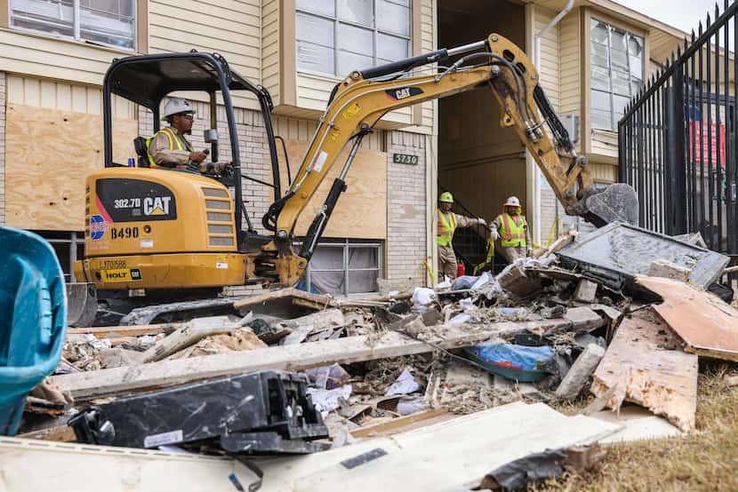 Workers remove debris from the apartment complex on Thursday, Sept. 30, 2021.