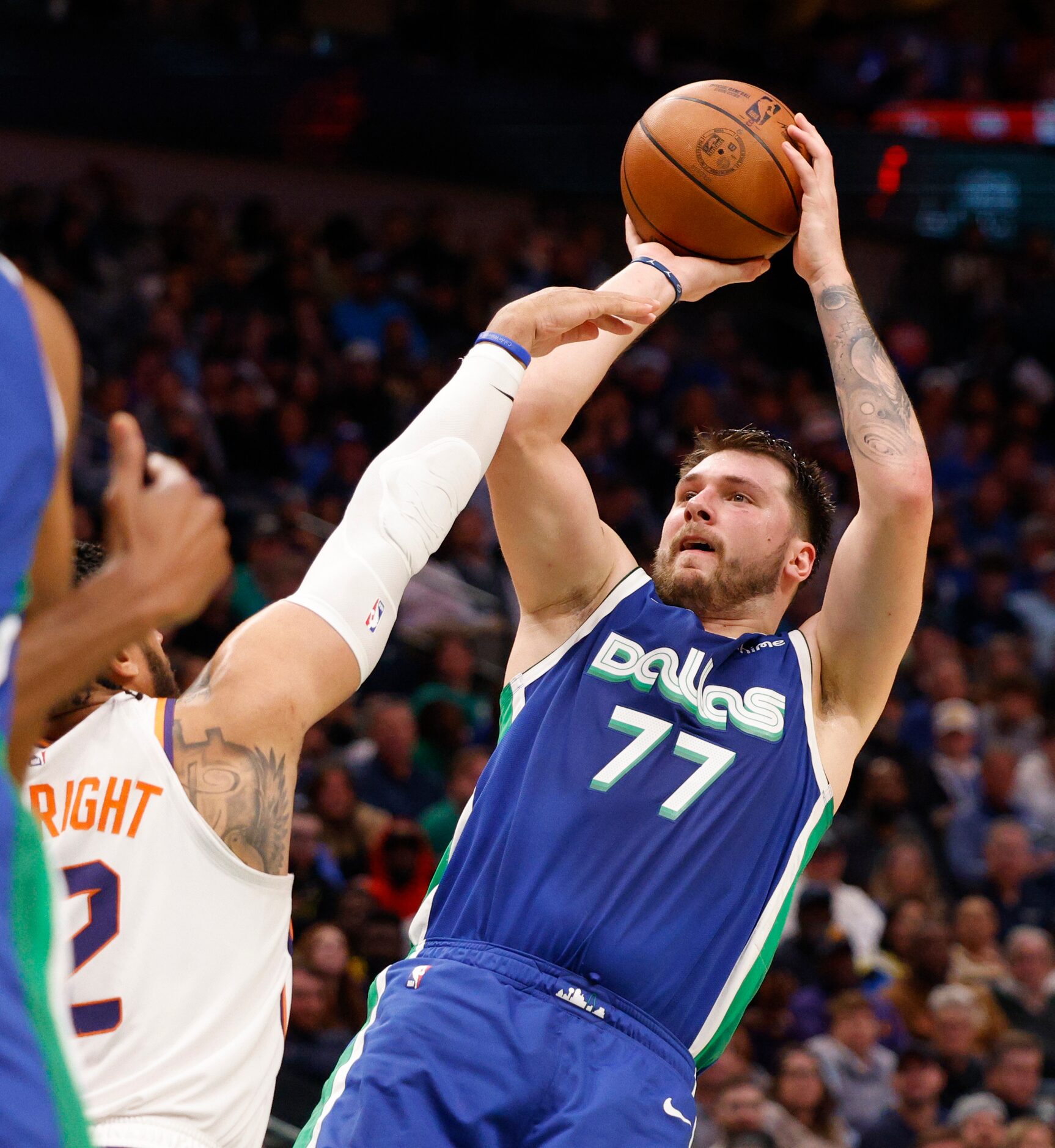 Dallas Mavericks guard Luka Doncic (77) shoots the ball over Phoenix Suns forward Ish...