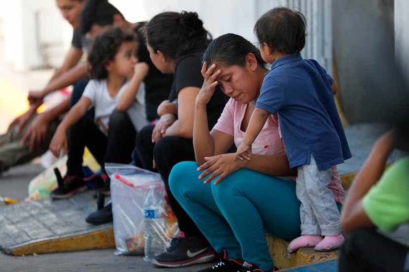 Migrantes esperan en un centro de inmigración en el Puente Internacionanl 1 en Nuevo Laredo,...