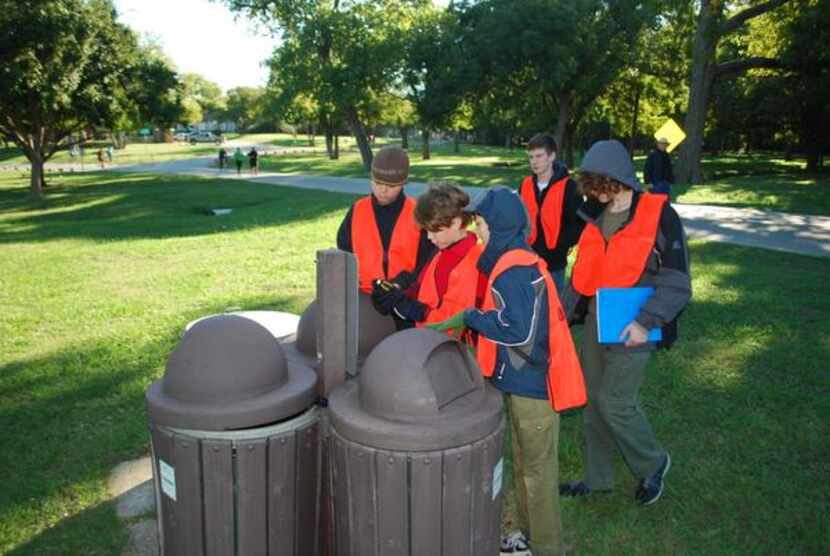
Nio Knight (center) reads the GPS coordinates for a cluster of trash cans at Winfrey Point...