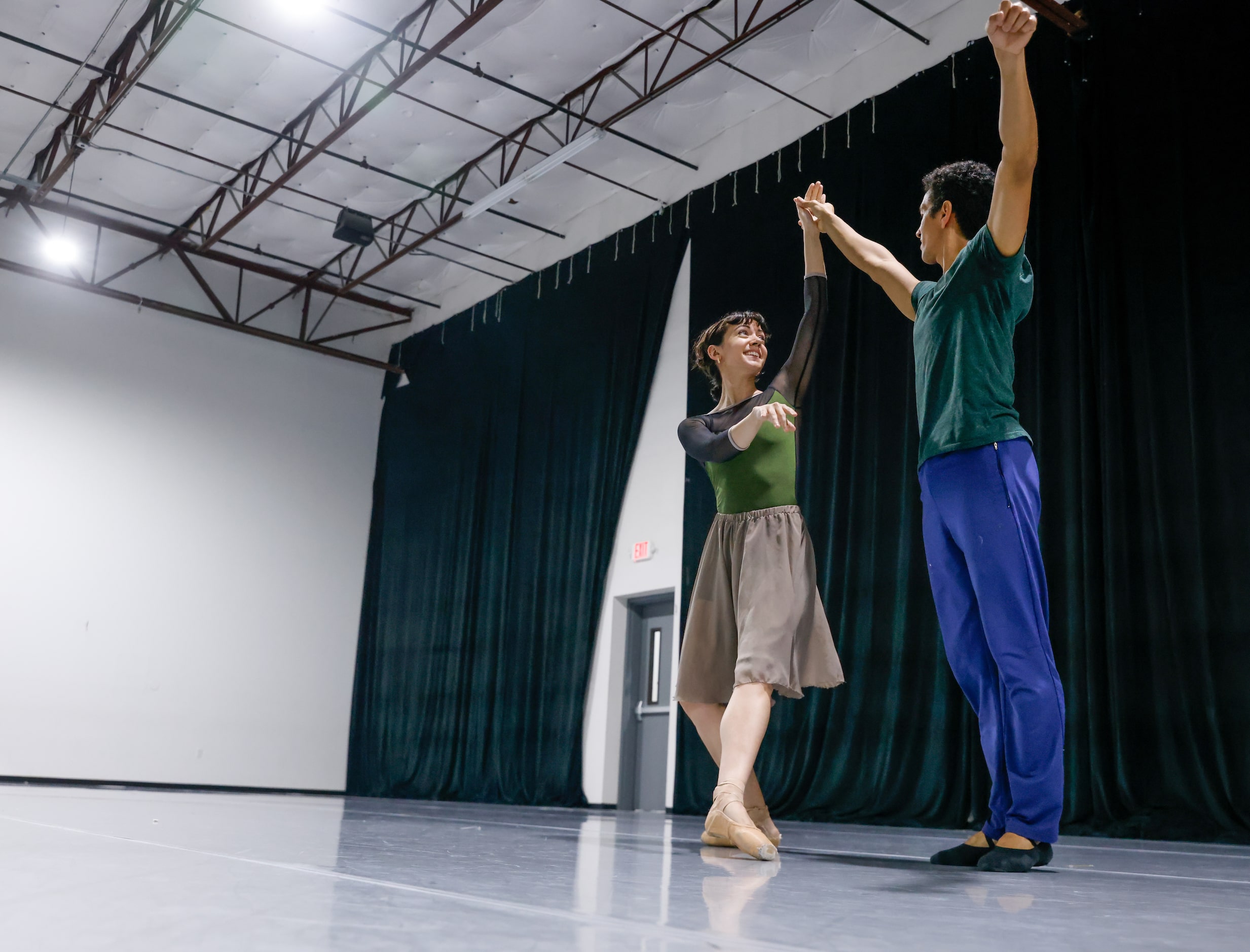 Alexandra F. Light (left) takes the hand of Joamanuel Velazquez as they rehearse a portion...