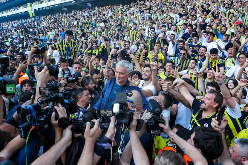 Portuguese soccer coach Jose Mourinho, center, poses for the media with supporters during...