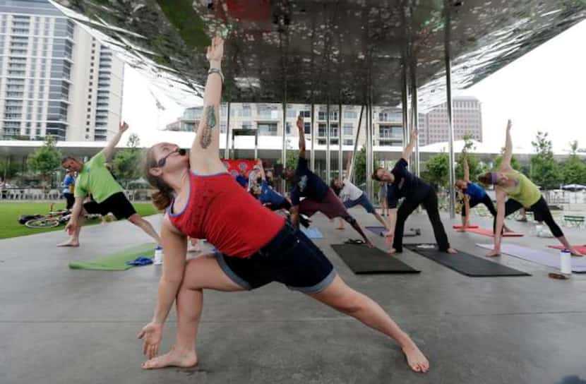 
Yoga instructor Mandee Carr leads a class at Klyde Warren Park during Uptown Ciclovía. The...