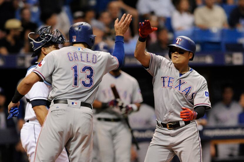 Texas Rangers' Joey Gallo (13) congratulates Shin-Soo Choo after scoring on Choo's two-run...