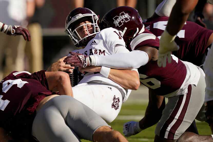 Texas A&M quarterback Max Johnson is tackled by Mississippi State defenders during the first...